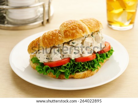 Chicken Salad Sandwich with Tomatoes and Lettuce on a Croissant with Iced Tea