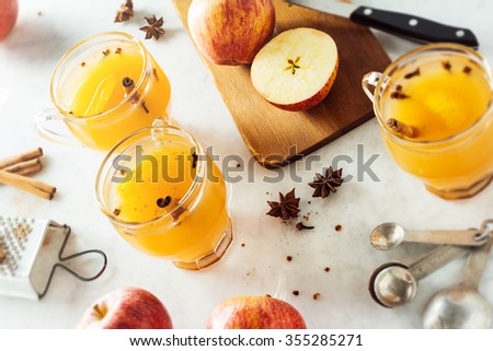 Mugs of Hot Spiced Mulled Apple Cider with Ingredients on Countertop