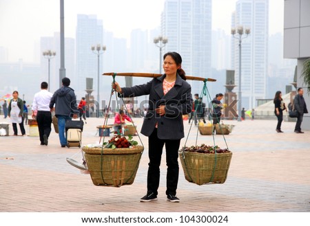 CHONGQING, CHINA - MARCH 18: An unidentified Chinese woman carrying vegetables on March 18, 2012 in Chongqing, China. The number of people living on less than $2/day is approximately 468 million, according to 2009 estimates.