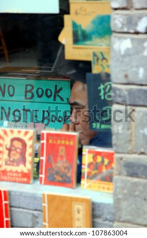 FENGHUANG - MARCH 23: A man inside a bookstore on March 23, 2012 in Fenghuang, China. China is the largest publisher of books in the world. Some 128,800 new titles of books were published in 2005.
