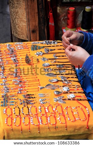 FENGHUANG - MARCH 23: A jewelry vendor on March 23, 2012 in Fenghuang, China. Jewelry making in China started 5,000 years ago but it became widespread with the spread of Buddhism 2,000 years ago.