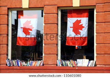TORONTO - JULY 22: Books on display on two windows and Canadian flags on July 22, 2012 in Toronto. A 2005 readership study reported that in Canada the average time spent reading is 4Â½ hours per week.