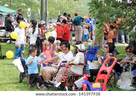 TORONTO - JUNE 23: Asian families in a park in a hot day on June 23, 2013 in Toronto. Based on 2011 census, there are 5.01 million Asian Canadian with the following ethnic identities.