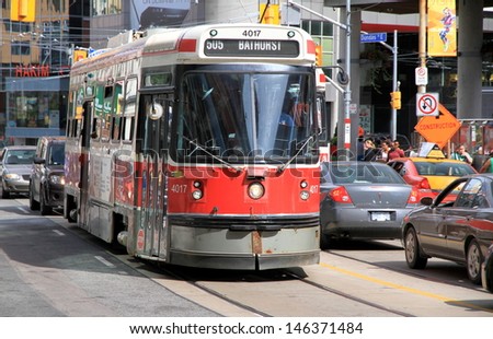 TORONTO - JULY 12: Streetcars in the city streets on July 12, 2013 in Toronto. The Toronto Transit Commission (TTC) current fleet includes 248 streetcars.