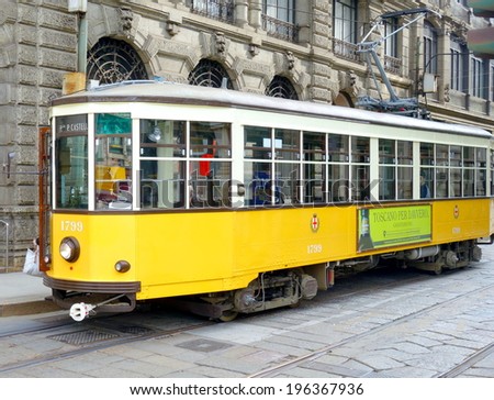 MILAN, ITALY - APRIL 12, 2014: Orange vintage tram  in a street of Milan city center.