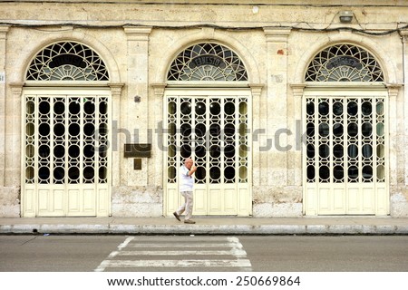 MATANZAS, CUBA - DECEMBER 14, 2014: A man walking in front of an old building in Matanzas, Cuba.