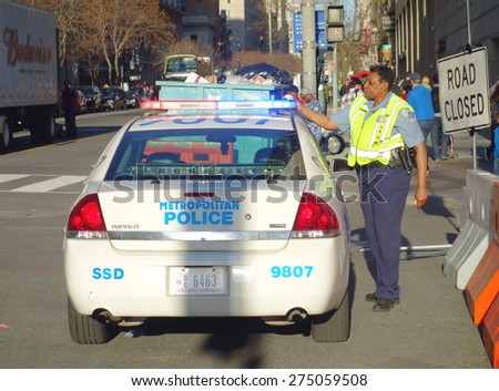 WASHINGTON DC, UNITED STATES OF AMERICA - APRIL 11, 2015: A Washington DC Metropolitan Police cruiser and and officer in a central street of the city.