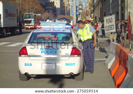 WASHINGTON DC, UNITED STATES OF AMERICA - APRIL 11, 2015: A Washington DC Metropolitan Police cruiser and and officer in a central street of the city.