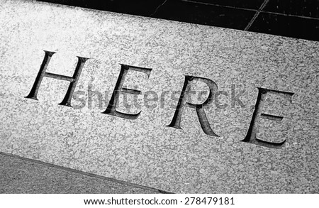 Word Here engraved in the stone