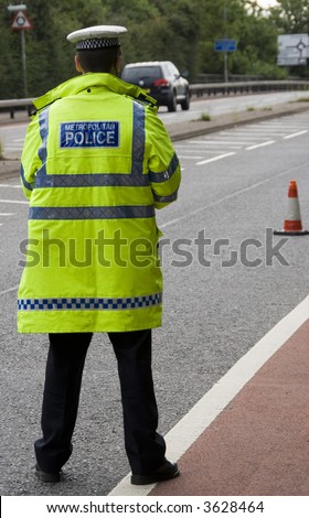 Traffic police officer waits standing in the road looking for on coming vehicles