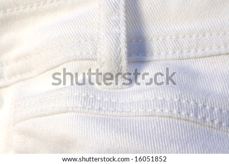 Detail of strap on a pair of white jeans
