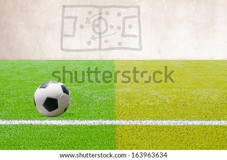 Soccer ball on artificial Soccer Field with a game plan.