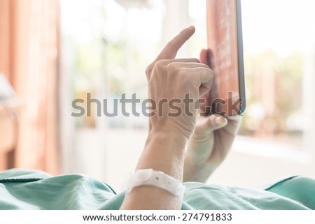 Mature female patient used tablet on bed in hospital