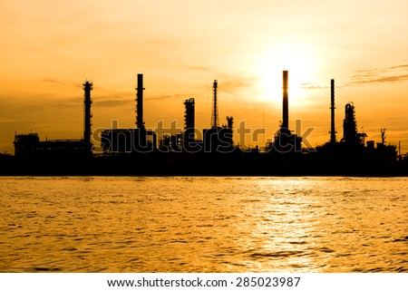 silhouette oil indutry refinery - factory with dramatic sunrise