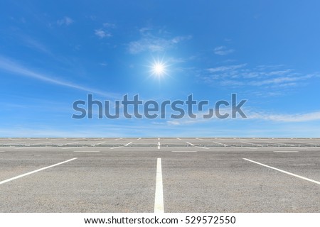 Empty parking lot on blue sky and sun reflection