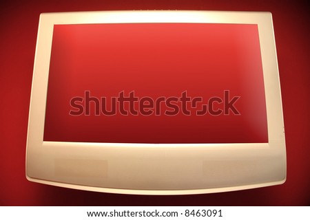 Plasma TV with transparent screen on red wall.