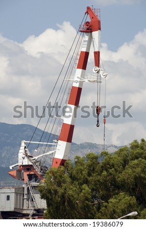 Shipbuilding crane. Red and white colored with nice clouds in background. heavy duty machinery.