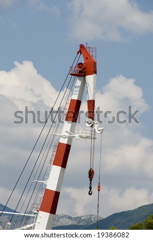 Shipbuilding crane. Red and white colored with nice clouds in background. heavy duty machinery.