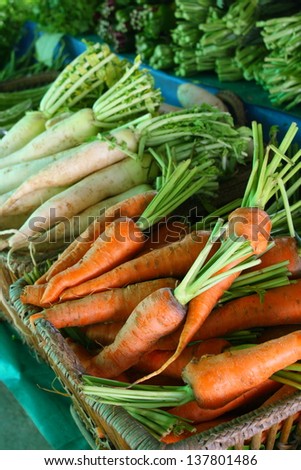 pile of organic carrot in wicker basket for retail sale in organic product market in thailand