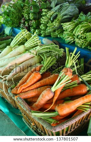 pile of organic carrot in wicker basket for retail sale in organic product market in thailand