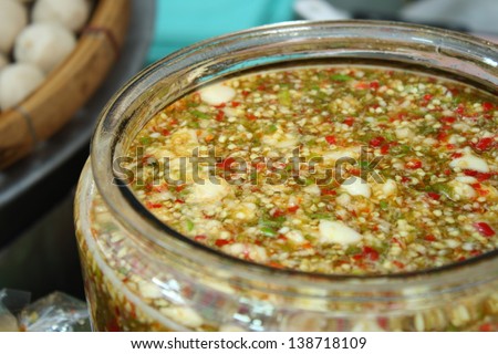 thai spicy seafood sauce in big jar before separate packing for retail sale in local market make of fish sauce, lemon juice, garlic, chilli, syrup