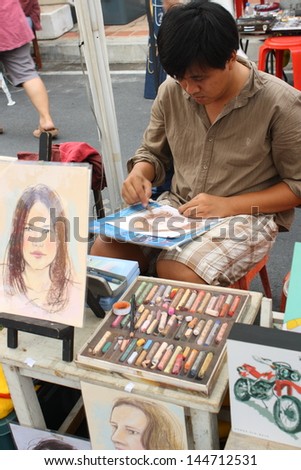 CHIANG MAI,THAILAND-JUNE 23 : an artist who draw portraits for customer, 30 minute wait for a picture  ,On June 23, 2013 in Chiang Mai, Thailand.
