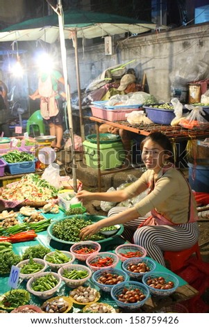 CHIANG MAI, THAILAND-OCTOBER11 : Native female merchant preparing fresh mushroom for retail sale at night time in a biggest wholesalemarket in chiang mai, On October 11, 2013, in Chiang Mai, Thailand.