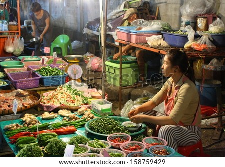 CHIANG MAI, THAILAND-OCTOBER11 : Native female merchant preparing fresh mushroom for retail sale at night time in a biggest wholesalemarket in chiang mai, On October 11, 2013, in Chiang Mai, Thailand.