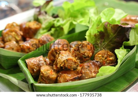 chopped Thai herbal sausage in banana leaf cup with lettuce. Northern thai sausage.