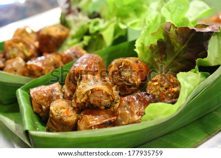 chopped Thai herbal sausage in banana leaf cup with lettuce. Northern thai sausage.