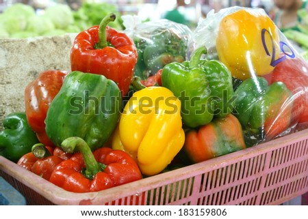colorful fresh organic sweet pepper (paprika) in an old plastic basket for retail sale in thailand local market