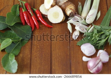 food ingredients of lemon grass soup (spicy Thai soup  or Tom Yam) include galangal, lime leaves, lime, lemon grass and red chili on wooden background.