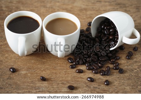 a cup of roasted coffee bean, a cup of hot black coffee, a cup of  instant coffee place on old wood background
