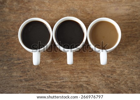two cup of  hot black coffee, a cup of  instant coffee place on old wood background. three cup of coffee on old wood background.