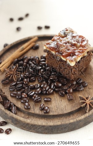 toffee cake with roasted coffee bean, cinnamon and chinese star aniseed on old wooden   plate