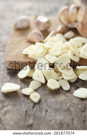 sliced garlic, garlic clove, garlic bulb place on chopping block on vintage wooden background