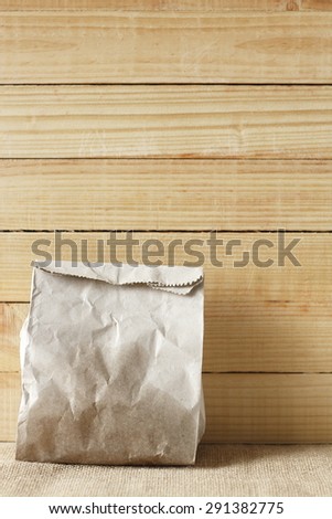 paper bag of some food in front of wooden background.