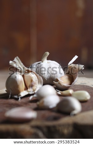 garlic clove, garlic bulb on chopping block made of a log