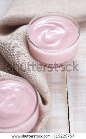 strawberry yogurt in glass with cloth place on white wooden background. pink yogurt. pink yoghurt, strawberry yoghurt.