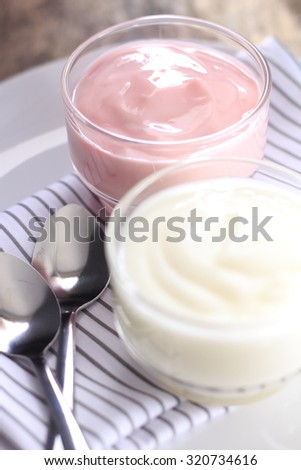plain yogurt and strawberry yogurt. yoghurt. yogurt in glass cup.