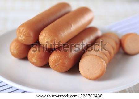 pieces of sausage and sausages in white dish. smoked sausages.pork sausage.
