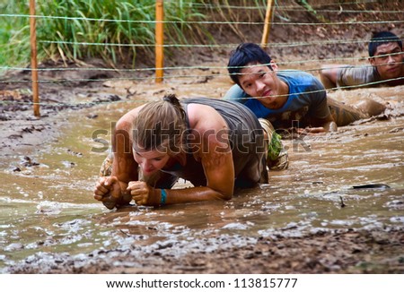 DALLAS, TEXAS - SEPTEMBER 15: Unidentified participants crawl through a mud pit in the Dash of the Titans Mud Run Race on September 15, 2012 in Dallas, Texas.