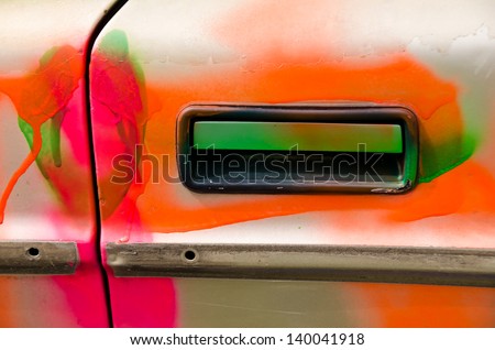 Door handle of an old car painted in psychedelic colors