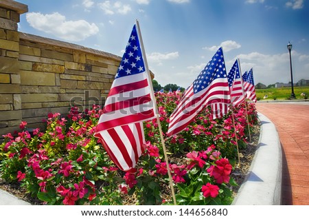 Row of American flags displayed on the street side in celebration of the 4th of July, shallow depth of field