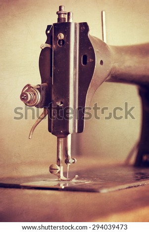 Old sewing machine on textured vintage background, closeup