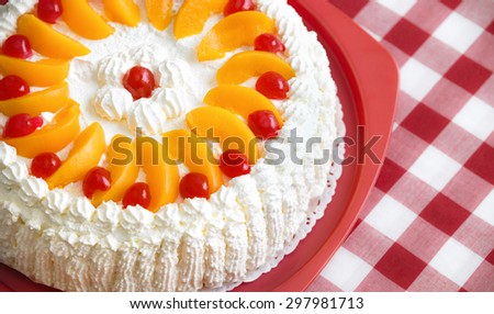 Homemade cream cake with peaches and cherries