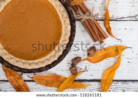 Pumpkin pie with autumn decorations on vintage wooden table. Top view.