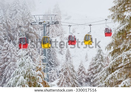Snowy trees and colorful rail car Dolomites Italy