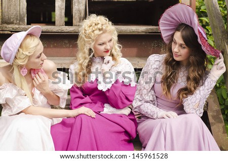 Three woman dressed in old fashion style are in an interesting lively talk