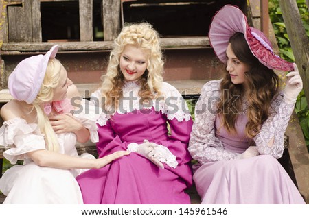 Three woman dressed in old fashion style are in an interesting lively talk